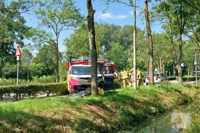 Elektrische bedrijfsbus raakt van de weg en belandt tegen boom