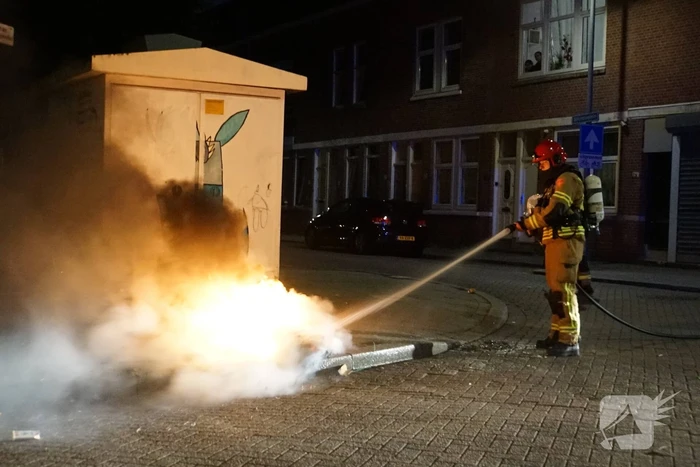 Brandweer blust brand naast afvalcontainer