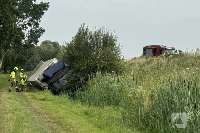 Vrachtwagen belandt in sloot naast snelweg, chauffeur ongedeerd