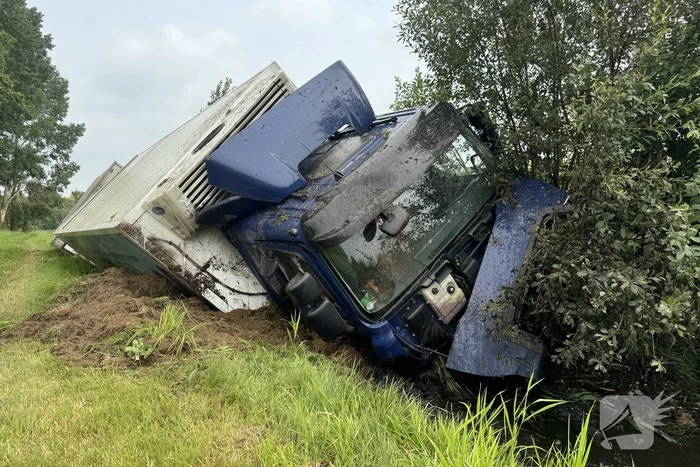 Vrachtwagen belandt in sloot naast snelweg, chauffeur ongedeerd