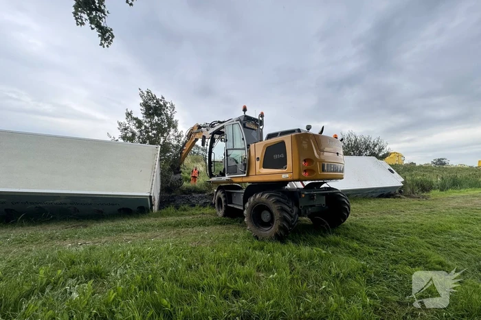 Vrachtwagen belandt in sloot naast snelweg, chauffeur ongedeerd