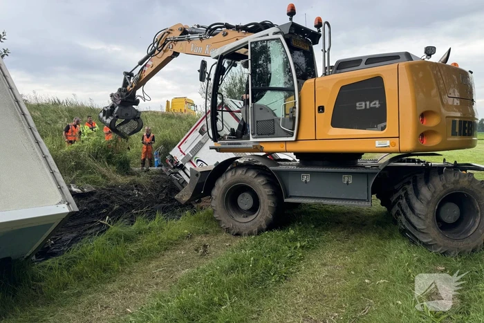 Vrachtwagen belandt in sloot naast snelweg, chauffeur ongedeerd