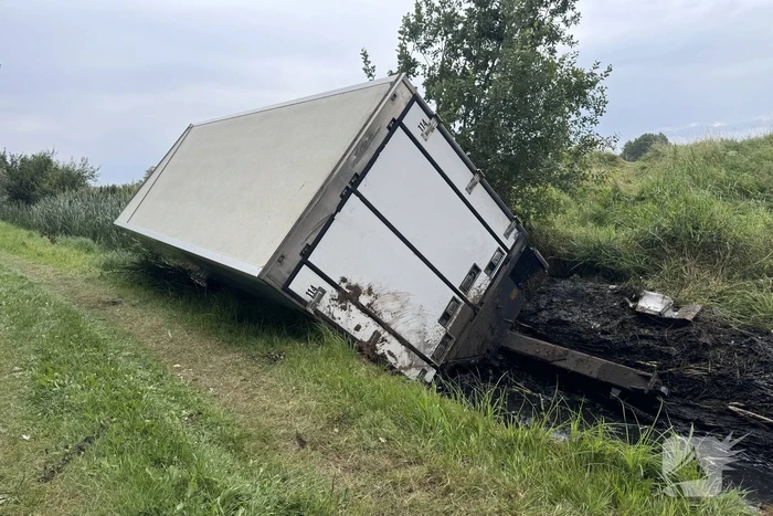 Vrachtwagen belandt in sloot naast snelweg, chauffeur ongedeerd