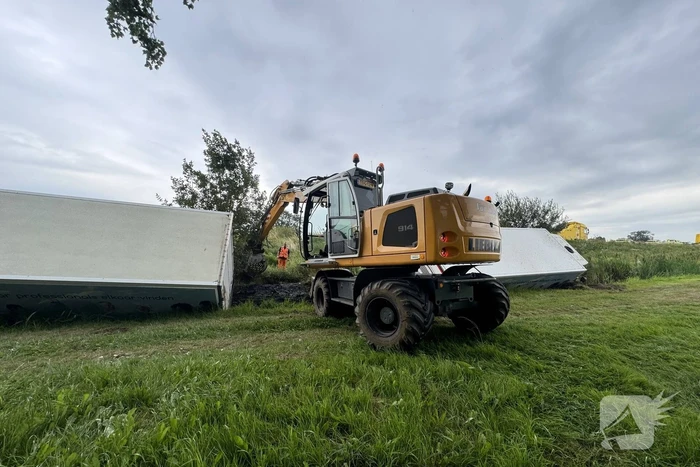 Vrachtwagen belandt in sloot naast snelweg, chauffeur ongedeerd