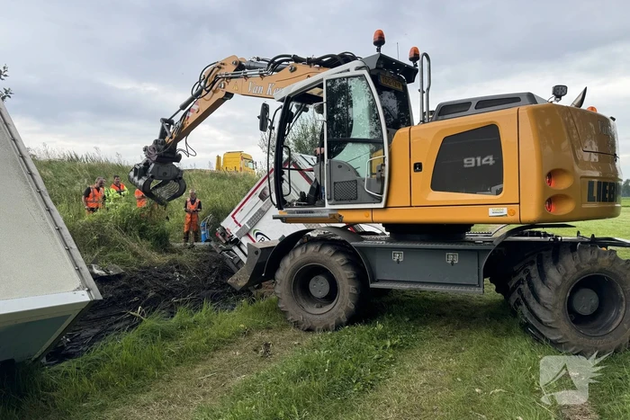 Vrachtwagen belandt in sloot naast snelweg, chauffeur ongedeerd
