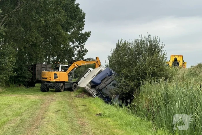 Vrachtwagen belandt in sloot naast snelweg, chauffeur ongedeerd