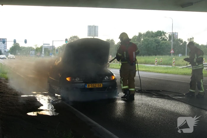 Brandweer blust brand onder motorkap