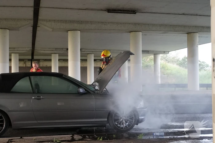 Brandweer blust brand onder motorkap