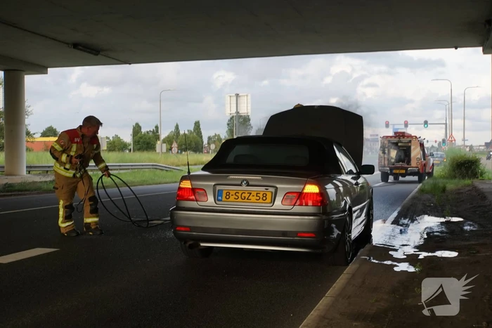 Brandweer blust brand onder motorkap