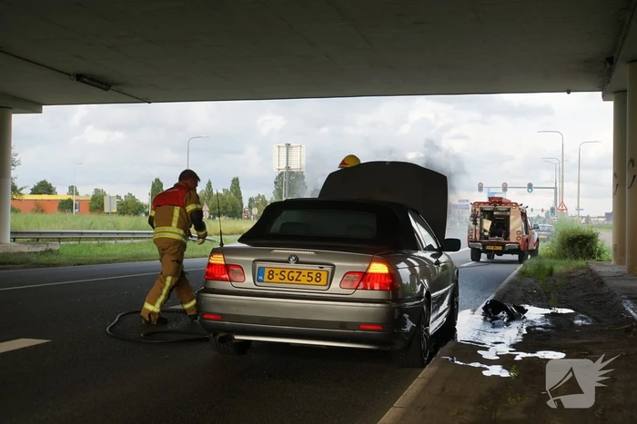 Brandweer blust brand onder motorkap
