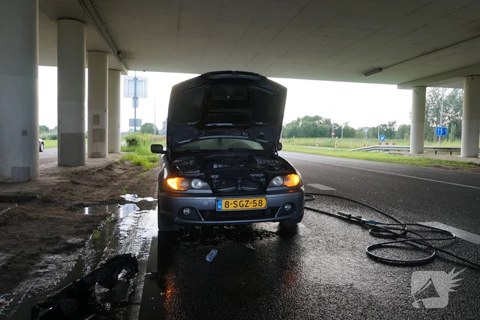 Brandweer blust brand onder motorkap