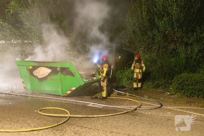 Metershoge vlammen door containerbrand