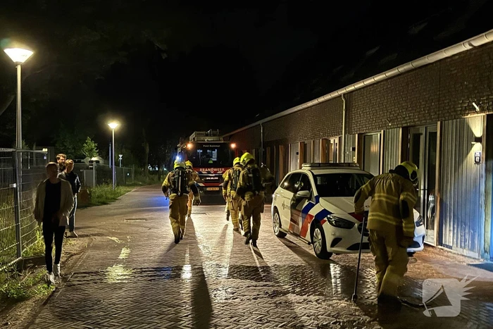 Vlammen slaan uit rietendak van woning