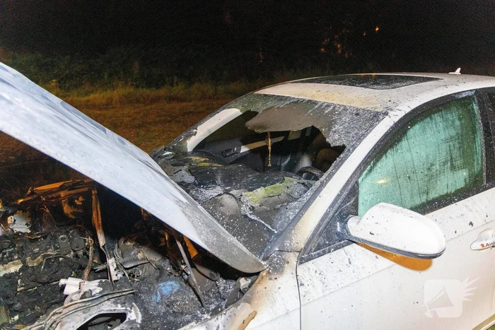 Voorzijde geparkeerde auto volledig verwoest door brand