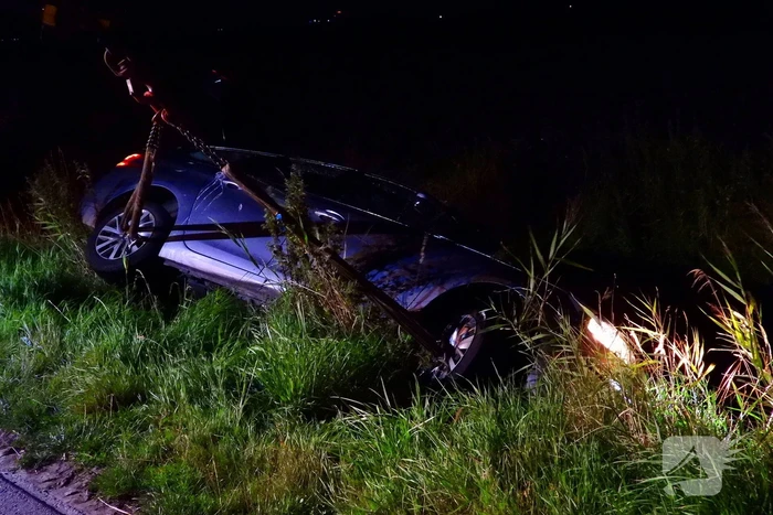 Auto vliegt uit de bocht en belandt ondersteboven in sloot