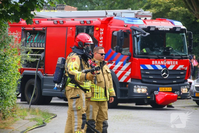 Brandweer blust brandende auto