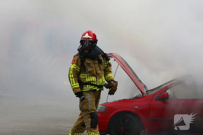 Brandweer blust brandende auto