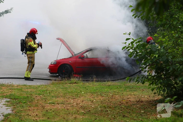 Brandweer blust brandende auto