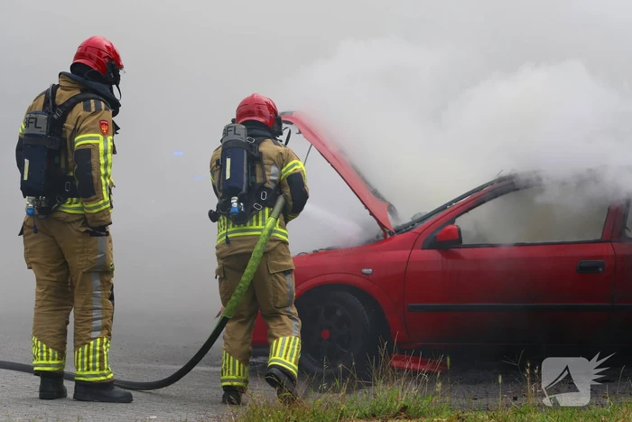 Brandweer blust brandende auto