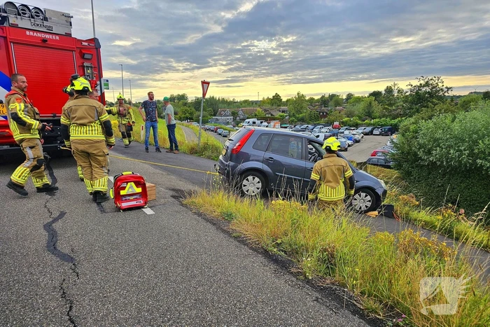 Brandweer trekt auto terug de dijk op