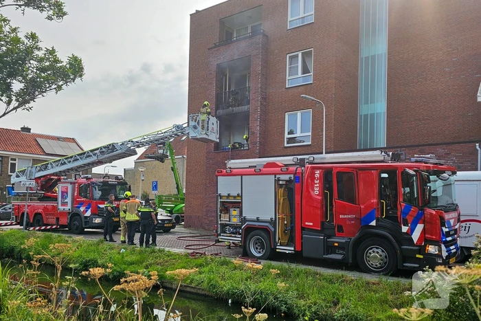Brandweer blust brand op balkon