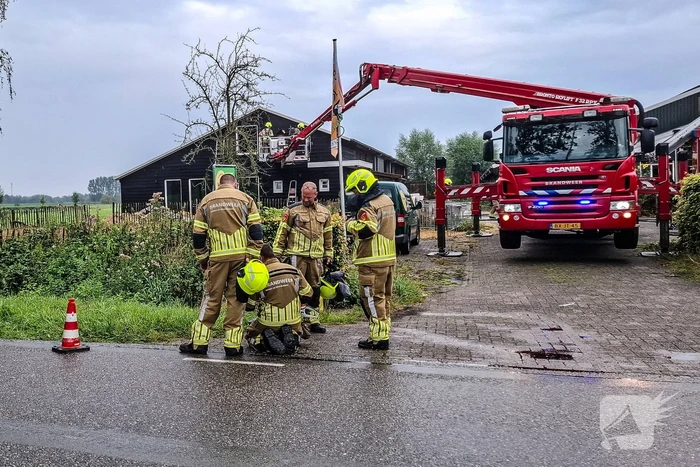 Brandweer blust brandende tussenmuur bij kaasboerderij