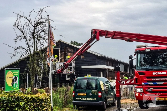 Brandweer blust brandende tussenmuur bij kaasboerderij