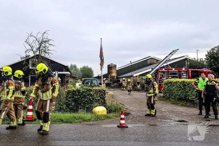 Brandweer blust brandende tussenmuur bij kaasboerderij