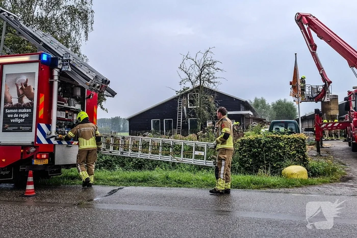 Brandweer blust brandende tussenmuur bij kaasboerderij