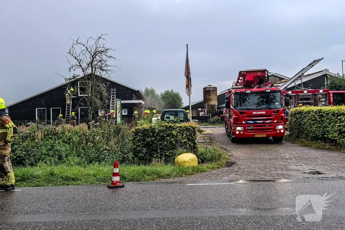 Brandweer blust brandende tussenmuur bij kaasboerderij