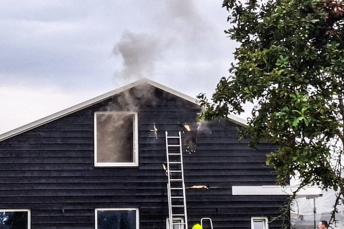 Brandweer blust brandende tussenmuur bij kaasboerderij