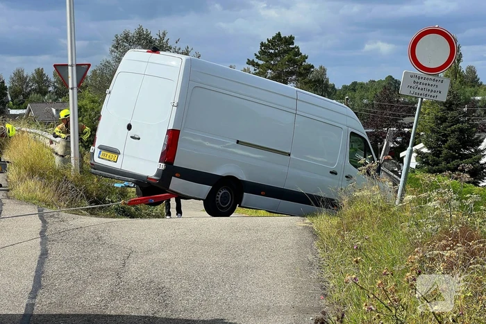 Bestelbus dreigt van talud te vallen