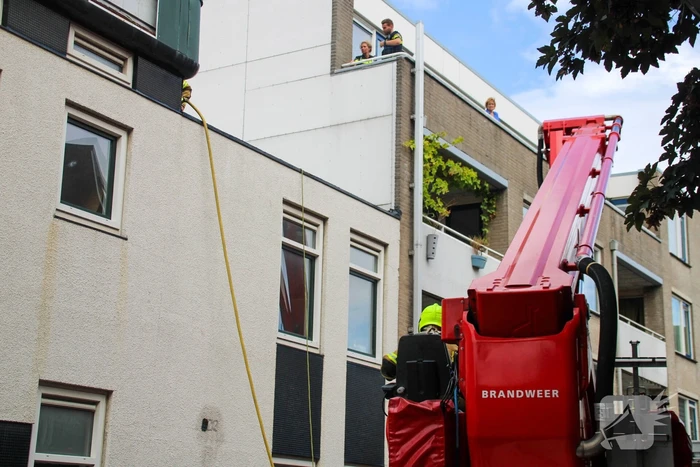 Veel rookontwikkeling bij brand op dak bij portiekwoning