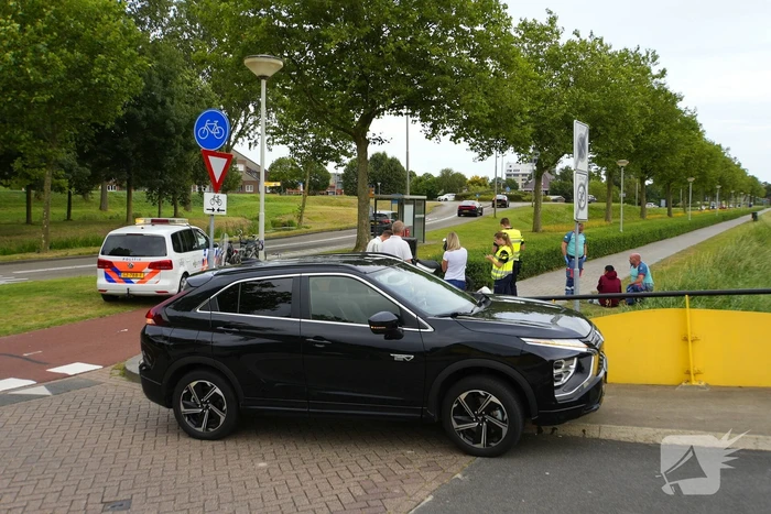 Scooterrijder komt ten val, ambulancepersoneel biedt hulp