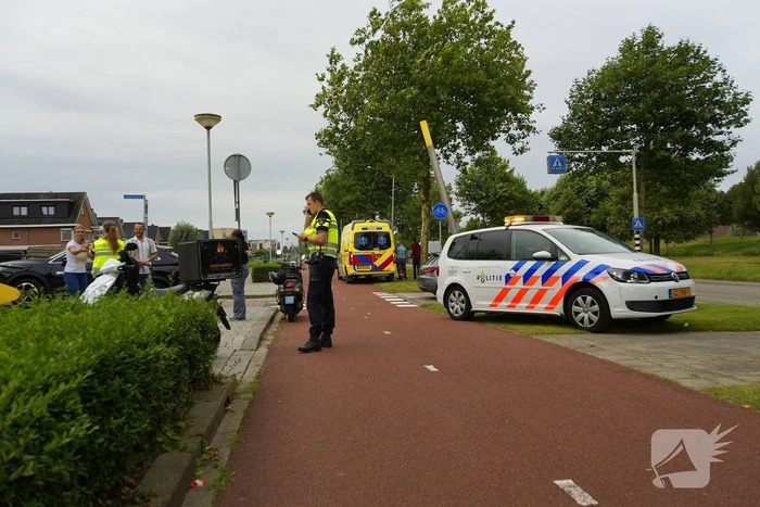 Scooterrijder komt ten val, ambulancepersoneel biedt hulp