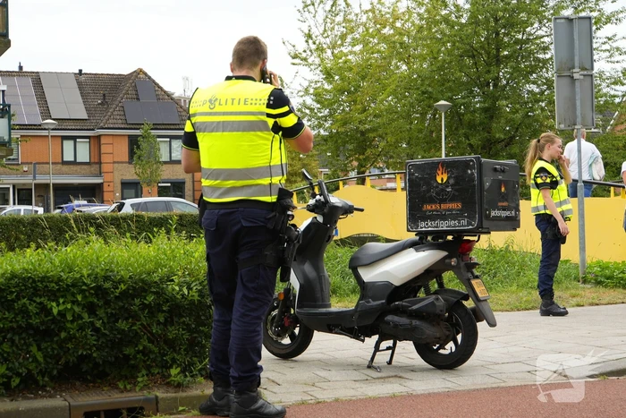 Scooterrijder komt ten val, ambulancepersoneel biedt hulp