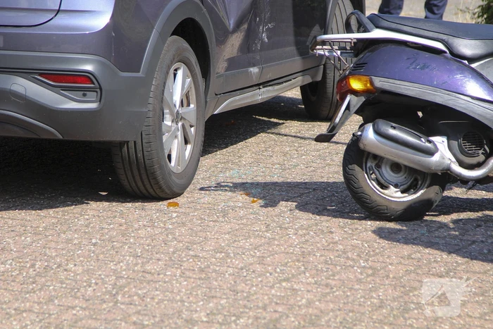 Scooterrijder klapt op achterportier van personenauto