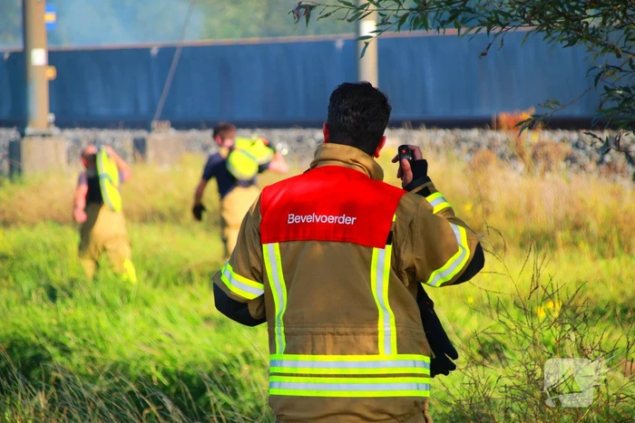 Tientallen meters bermbrand achter spoor moeilijk bereikbaar