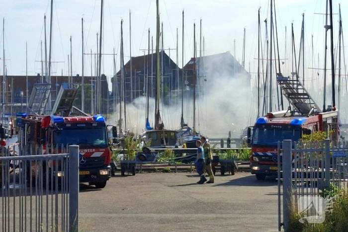 Veel rook in haven door brandend vaartuig