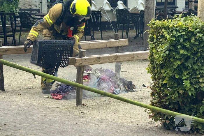 Brand in wasmand vol handdoeken bij restaurant