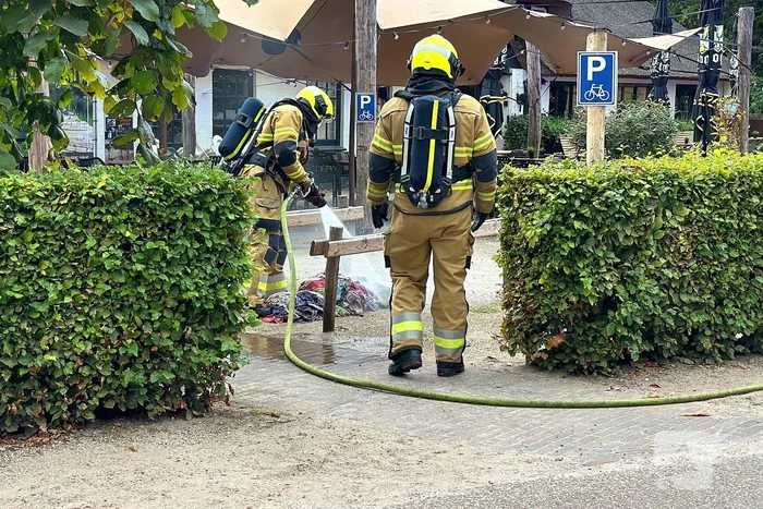 Brand in wasmand vol handdoeken bij restaurant