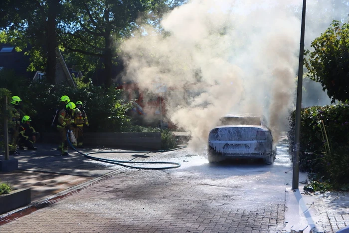 Felle autobrand slaat over naar heg