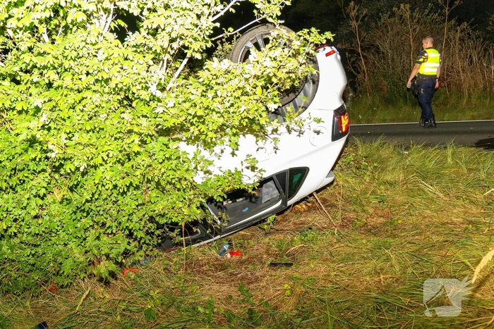 Auto belandt op de kop in bosschages