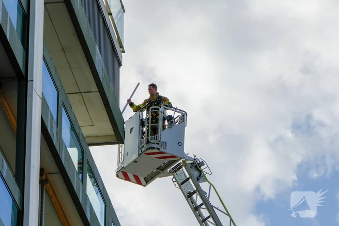 Hoogwerker ingezet bij stormschade aan flatgebouw