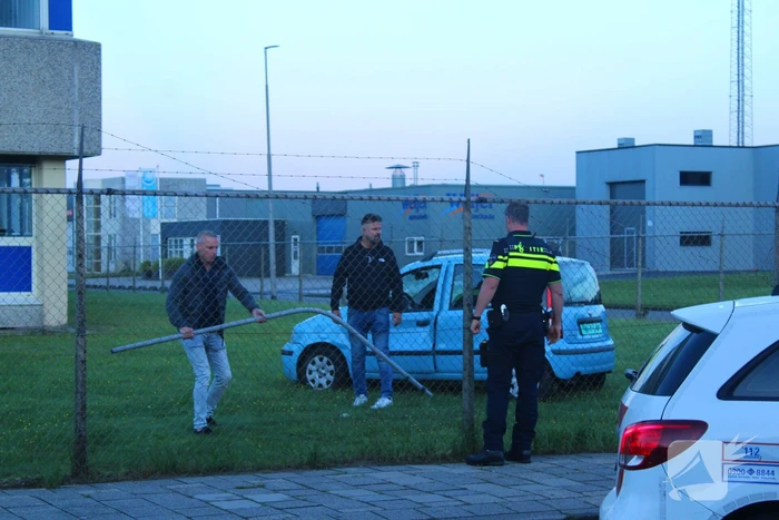 Personenauto rijdt door hek na botsing