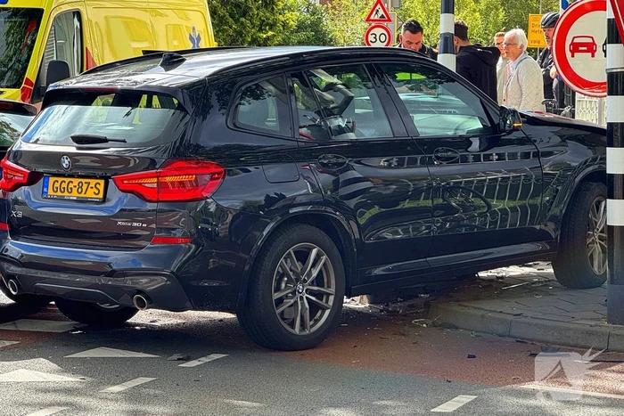 Twee voertuigen botsen op elkaar waarna een op een verkeerslicht klapt