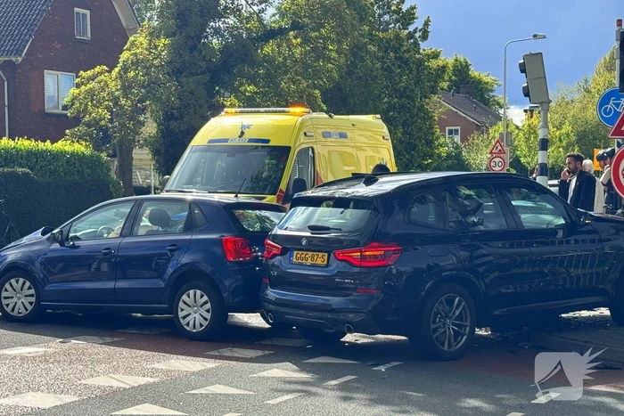 Twee voertuigen botsen op elkaar waarna een op een verkeerslicht klapt