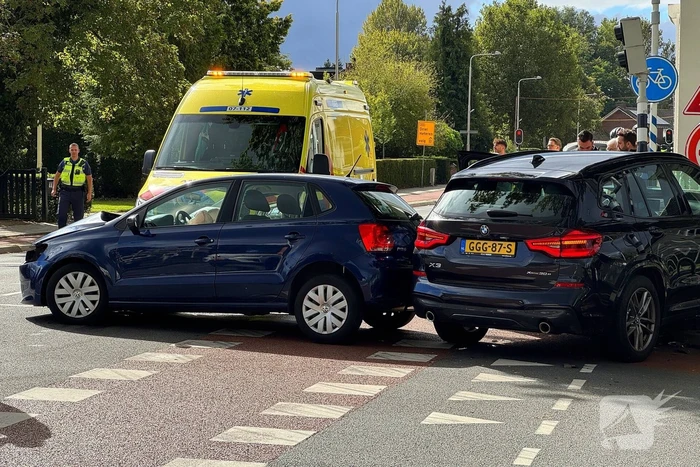 Twee voertuigen botsen op elkaar waarna een op een verkeerslicht klapt