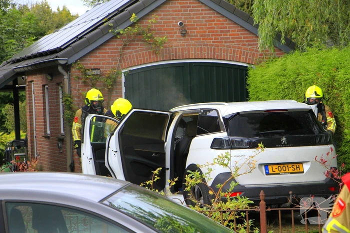 Personenauto vat vlam op oprit