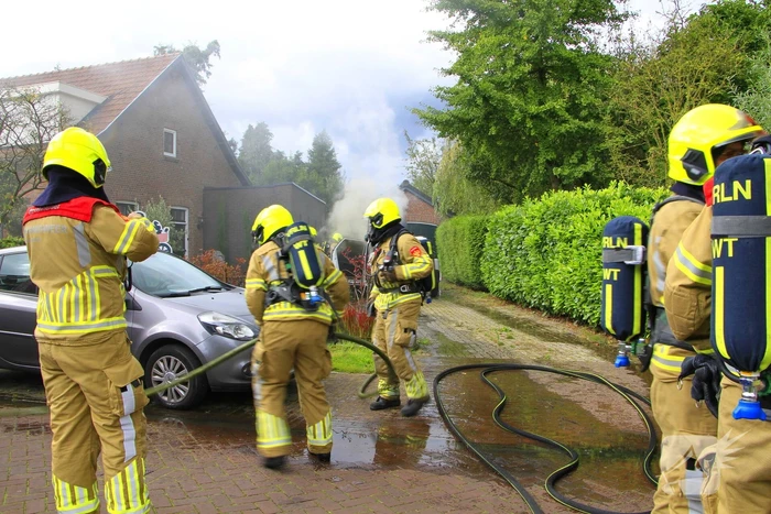 Personenauto vat vlam op oprit